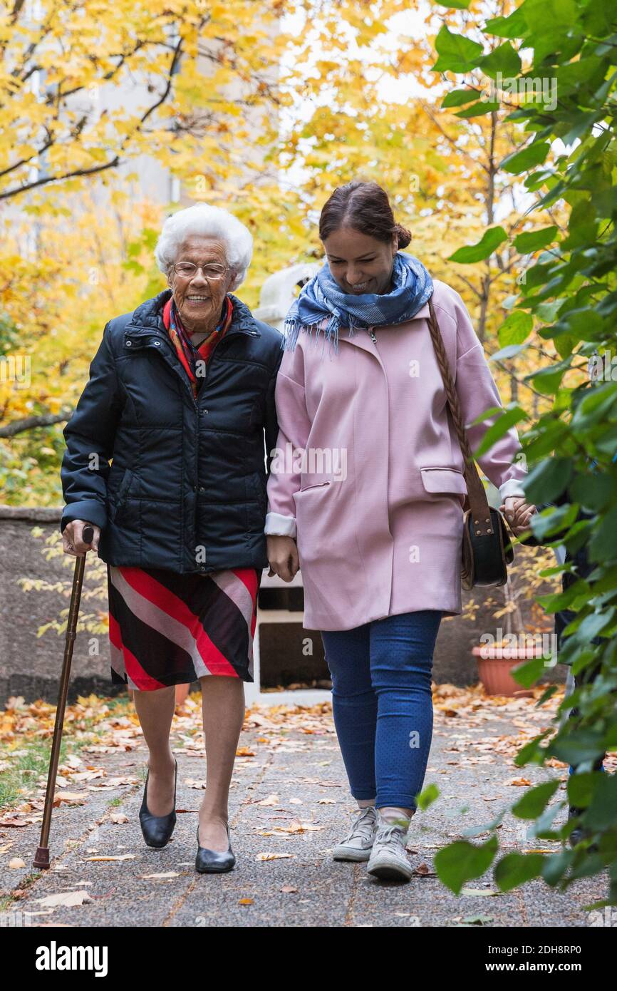 Volle Länge der älteren Frau zu Fuß mit Tochter im Park Stockfoto