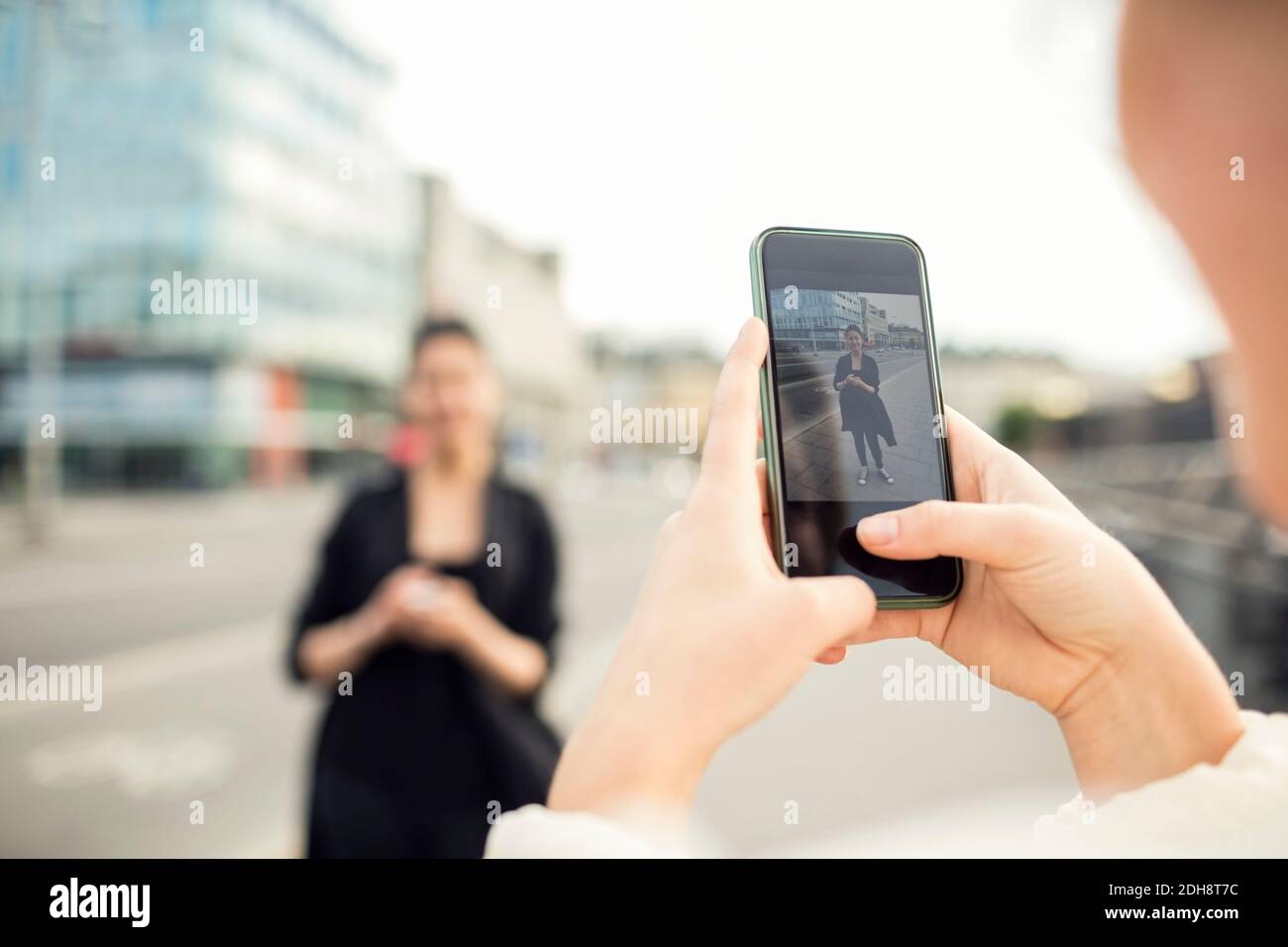 Zugeschnittenes Bild einer Frau, die einen Freund in der Stadt fotografiert Stockfoto