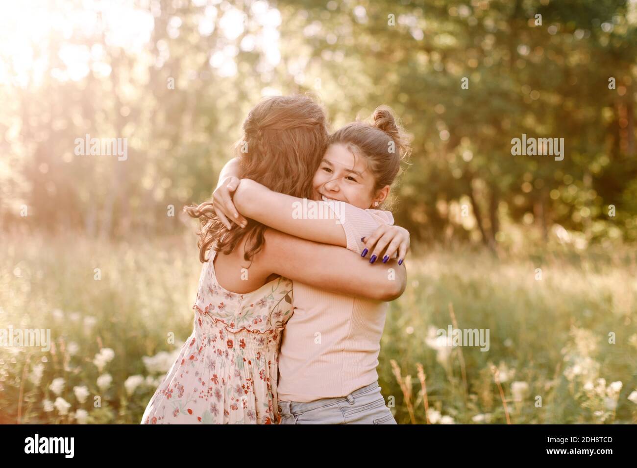 Glückliche Geschwister umarmen einander im Hinterhof Stockfoto