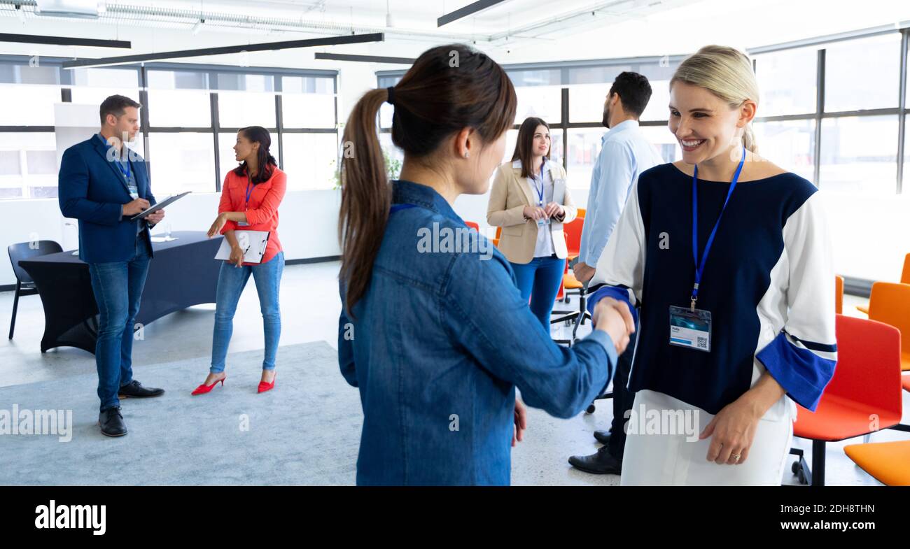 Geschäftsfrauen, die sich in einem Büro die Hände schütteln Stockfoto