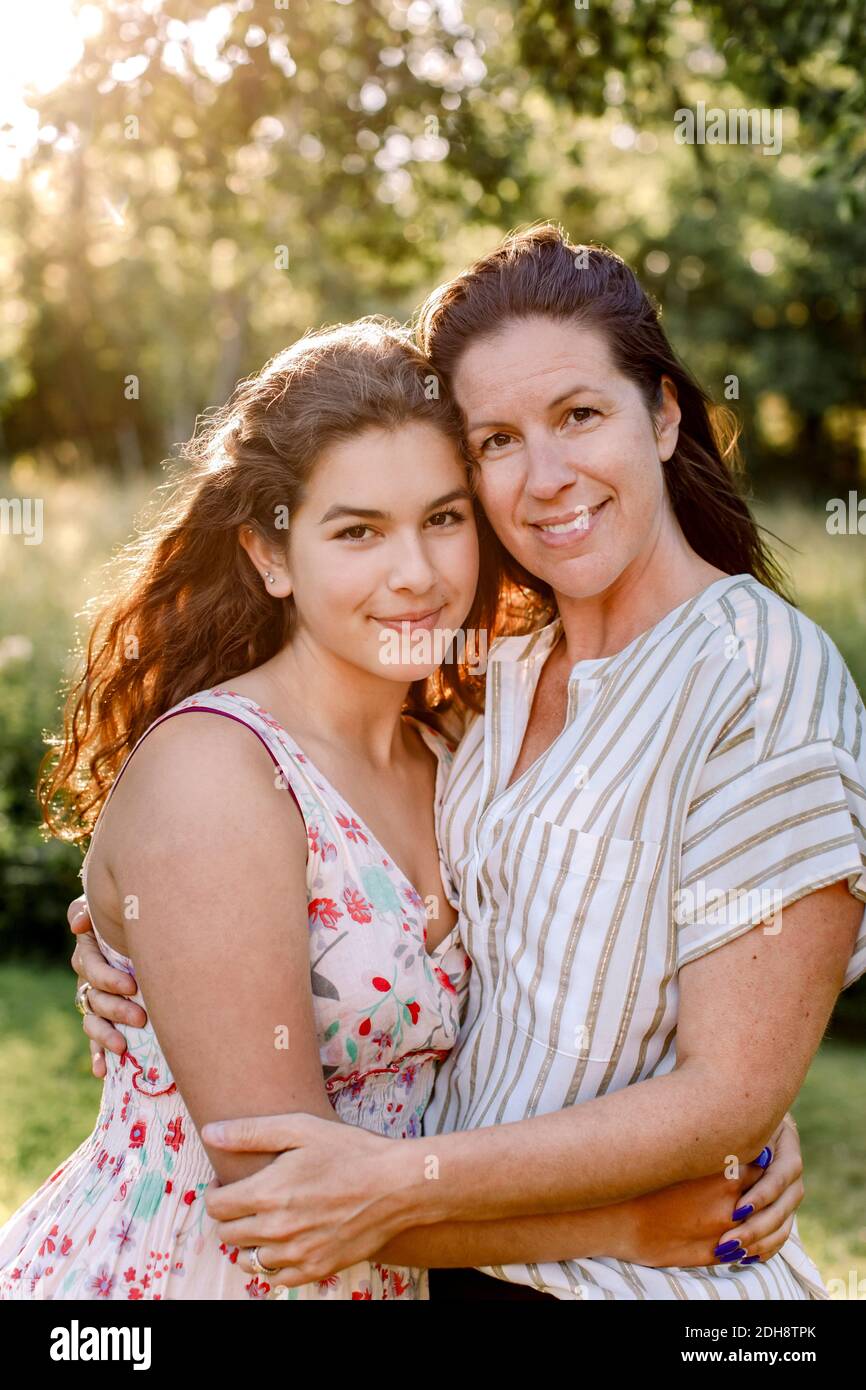 Portrait von lächelnder Mutter und Tochter im Hof Stockfoto