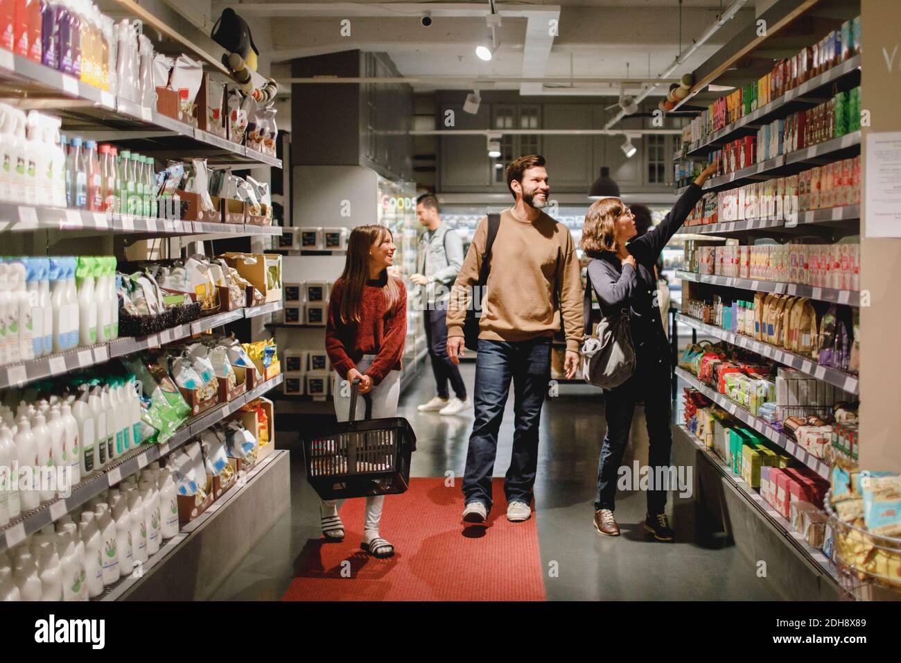 Lächelnde Familie mit Tochter einkaufen im Supermarkt Stockfoto