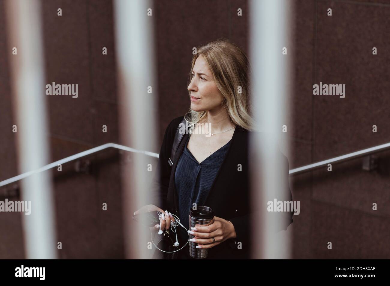 Betrachten Geschäftsfrau mit Kaffeetasse Blick weg in der Stadt Stockfoto