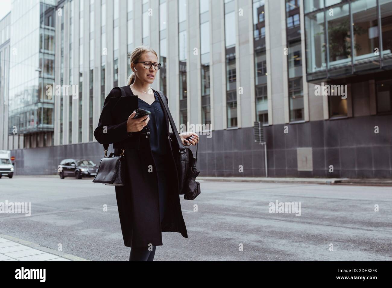 Betrachten Geschäftsfrau mit Smartphone zu Fuß in der Stadt Stockfoto