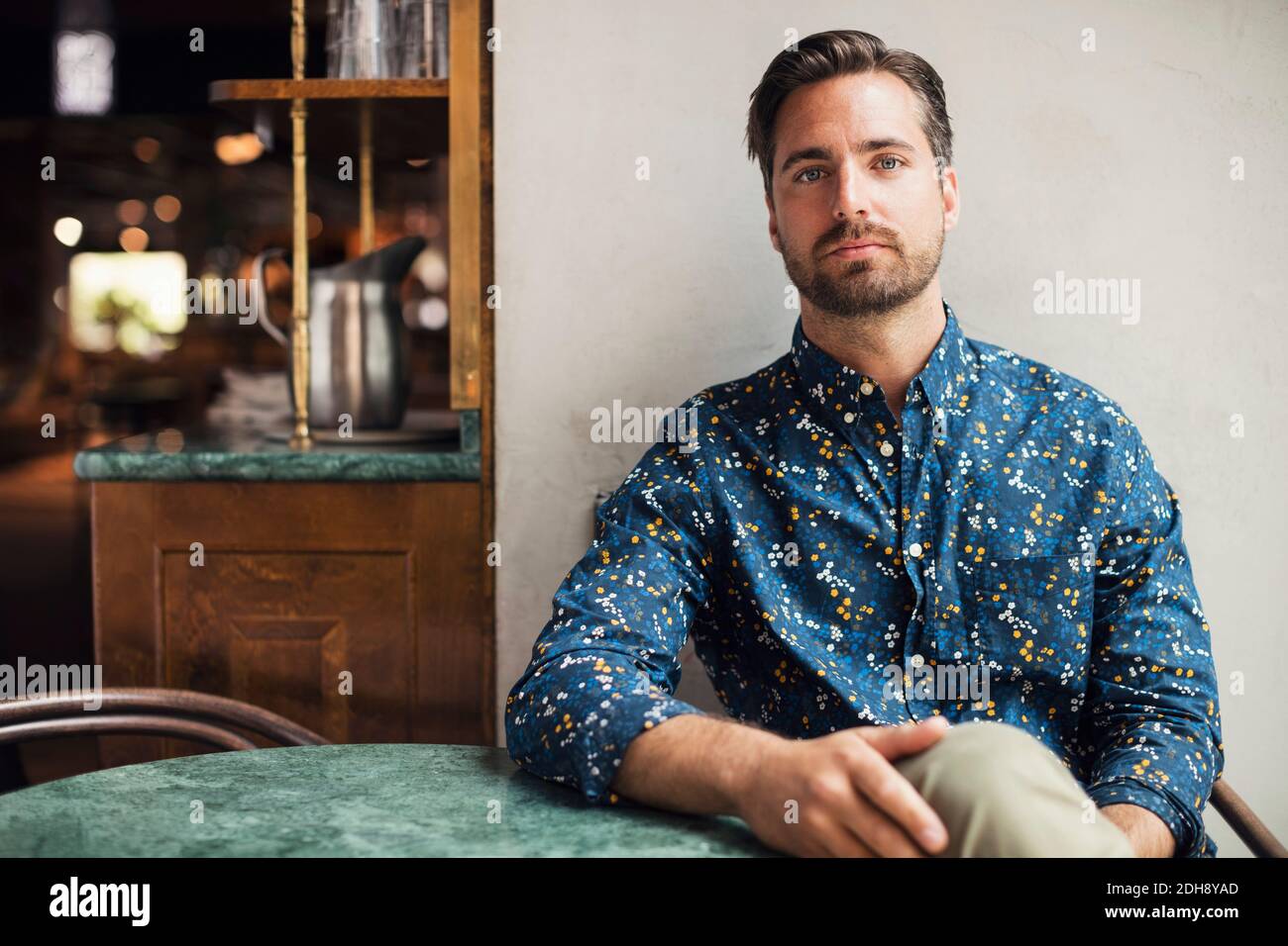 Porträt des selbstbewussten mittleren Erwachsenen Geschäftsmann sitzt am Tisch in Restaurant Stockfoto