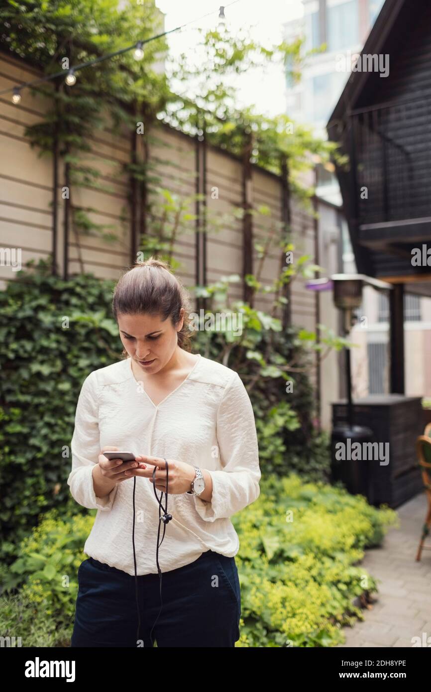 Geschäftsfrau mit Smartphone im Büro Hof Stockfoto