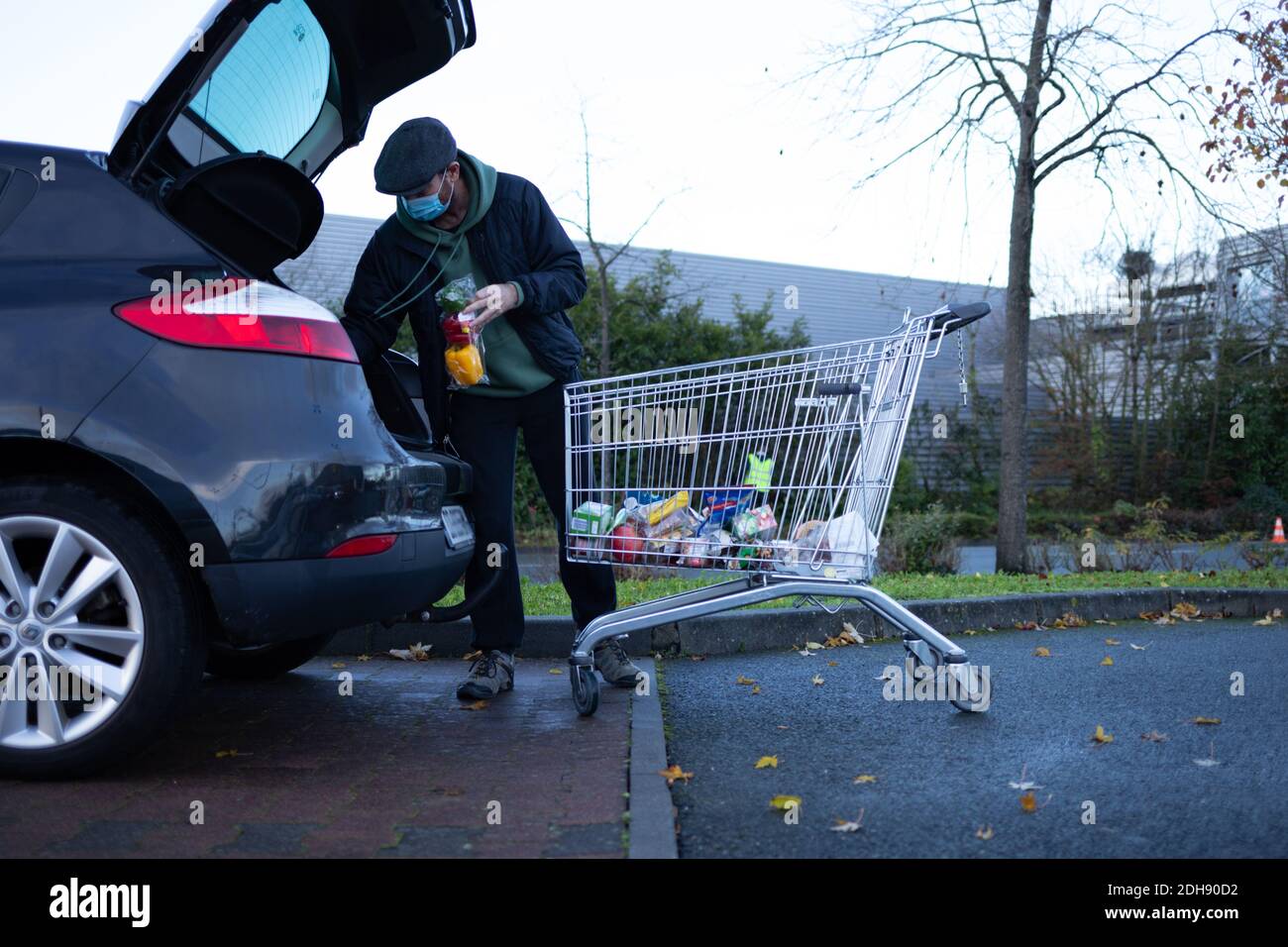 Angers, Maine und Loire, Frankreich - 10. Dezember 2020: Der Mensch lädt Einkäufe in den Kofferraum seines Autos Stockfoto