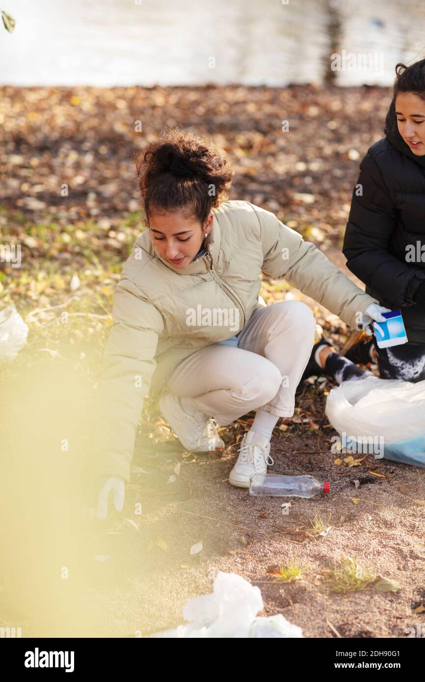 Junge Umweltschützerin mit Teenager, die Mikroplastik beim Anhocken halten Land Stockfoto