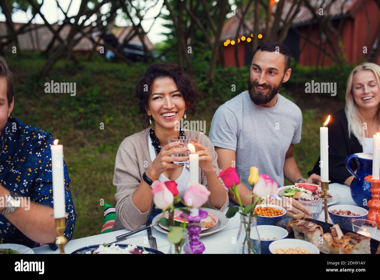 Glückliche Freunde genießen das Essen auf der Gartenparty Stockfoto