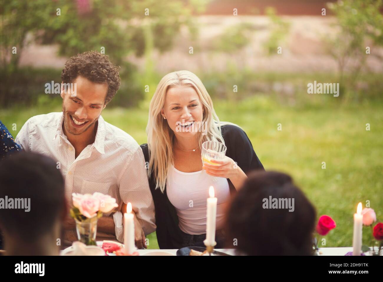 Glückliche Freunde genießen das Essen auf der Gartenparty Stockfoto