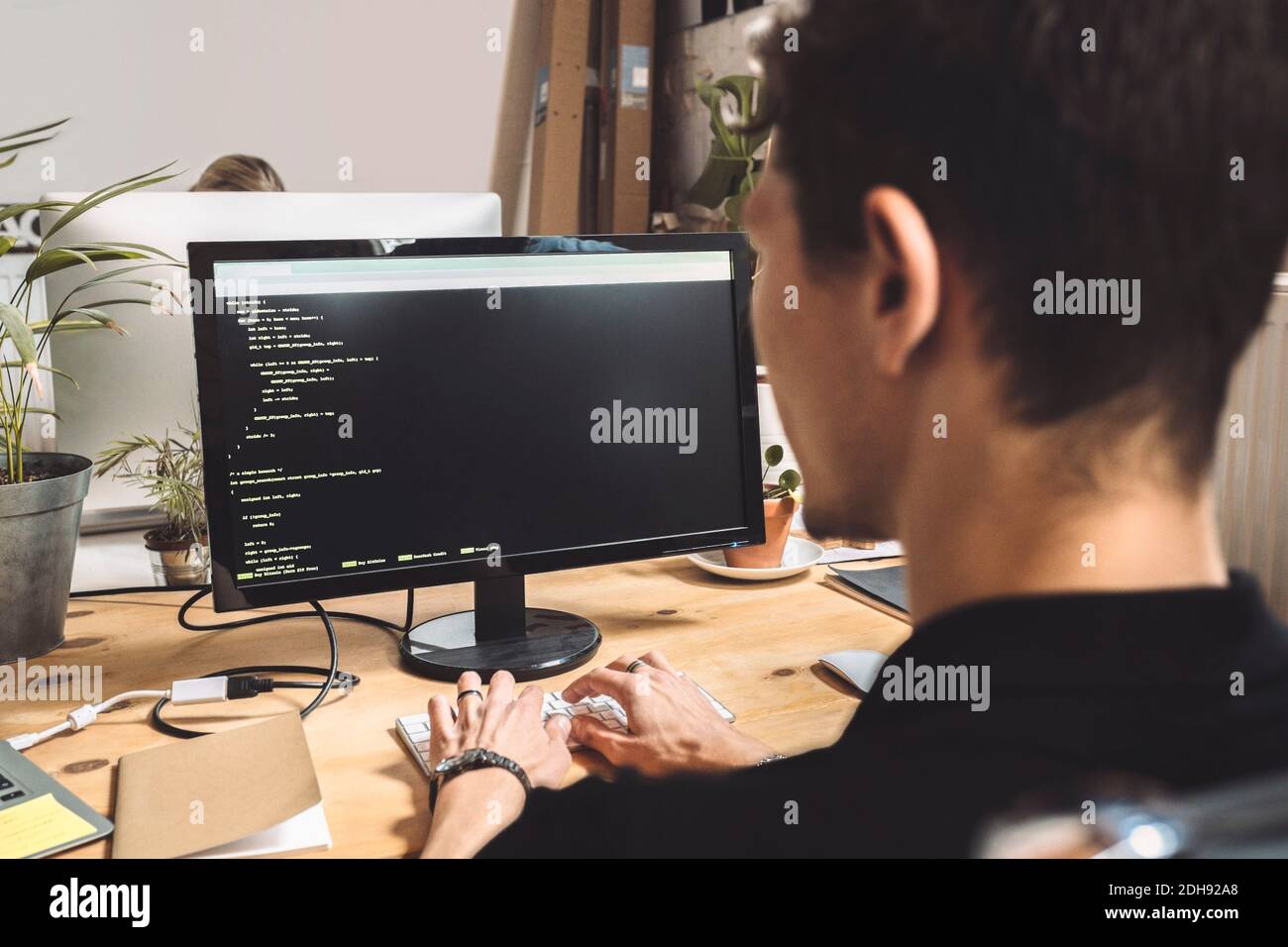 Computerprogrammierer, der auf dem Desktop am Arbeitsplatz codiert Stockfoto