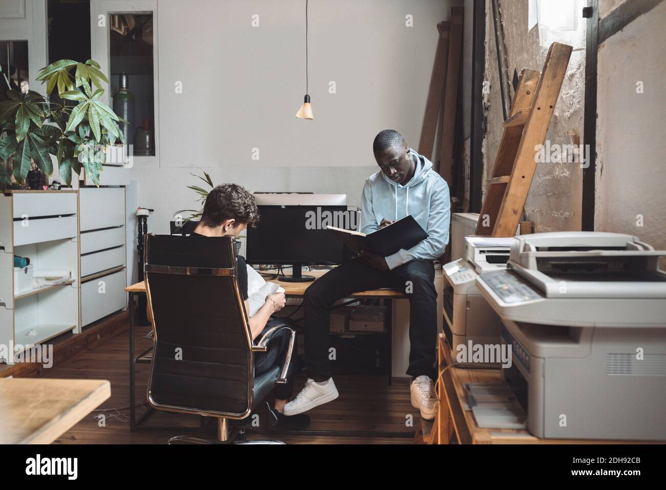Computer-Programmierer lesen Buch für die Codierung am Arbeitsplatz Stockfoto