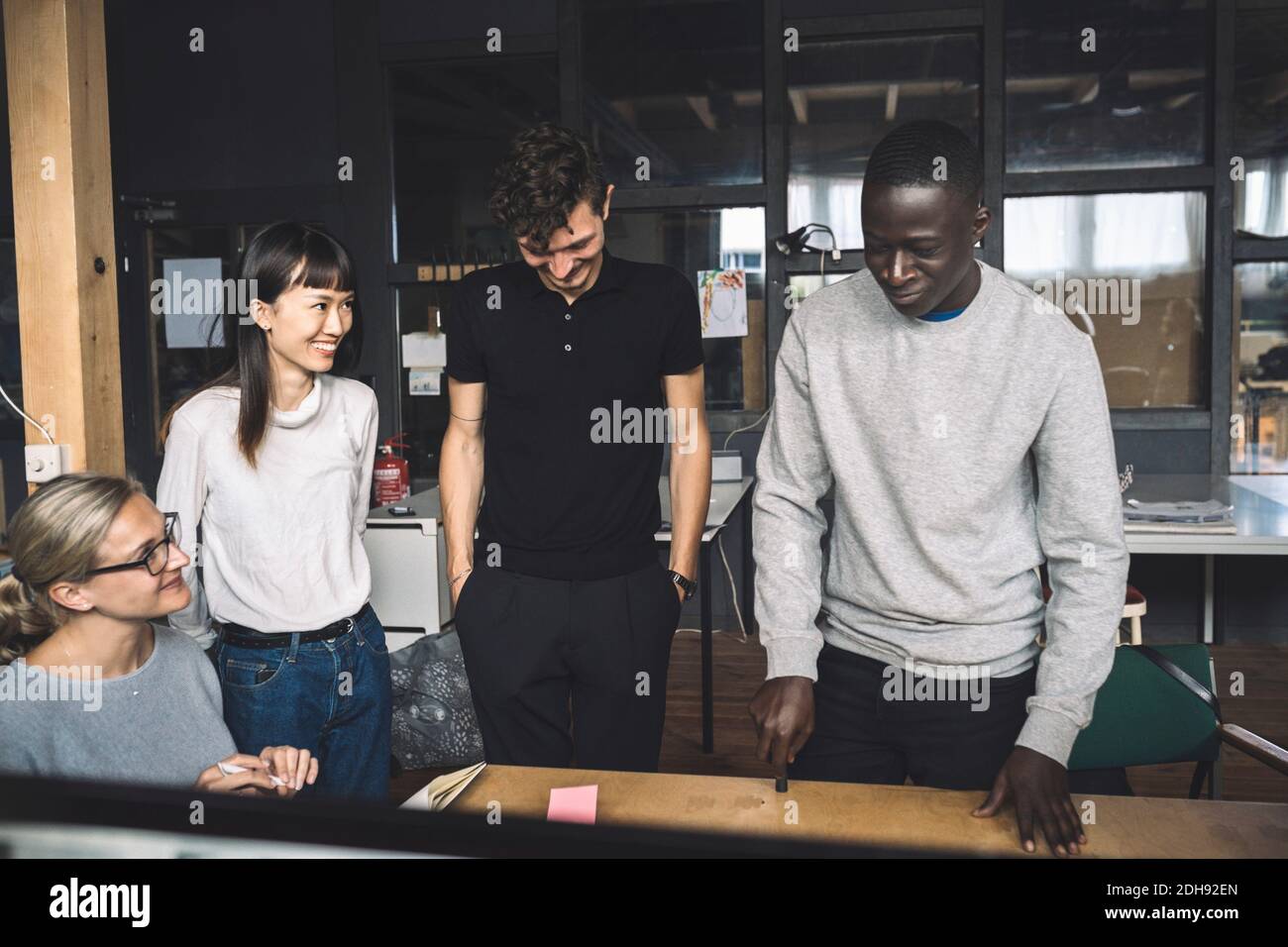 Lächelnde Kollegen diskutieren über die Start-up-Strategie am Arbeitsplatz Stockfoto