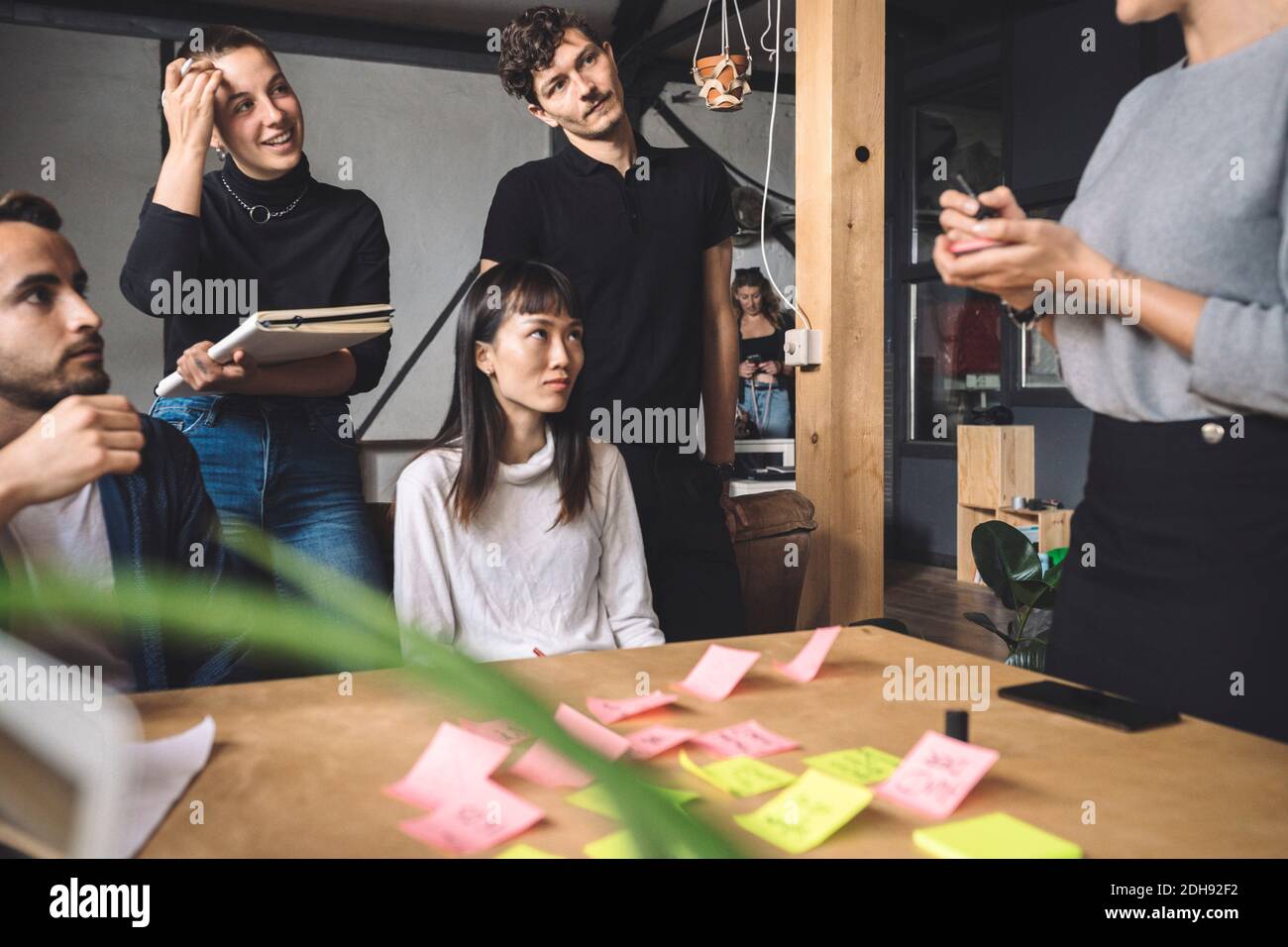 Mittelteil der Geschäftsfrau mit Mitarbeitern am Arbeitsplatz Stockfoto