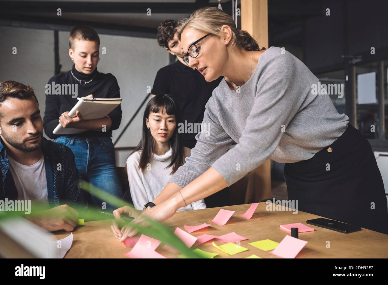 Geschäftsfrau im Gespräch mit Kollegen am Arbeitsplatz Stockfoto