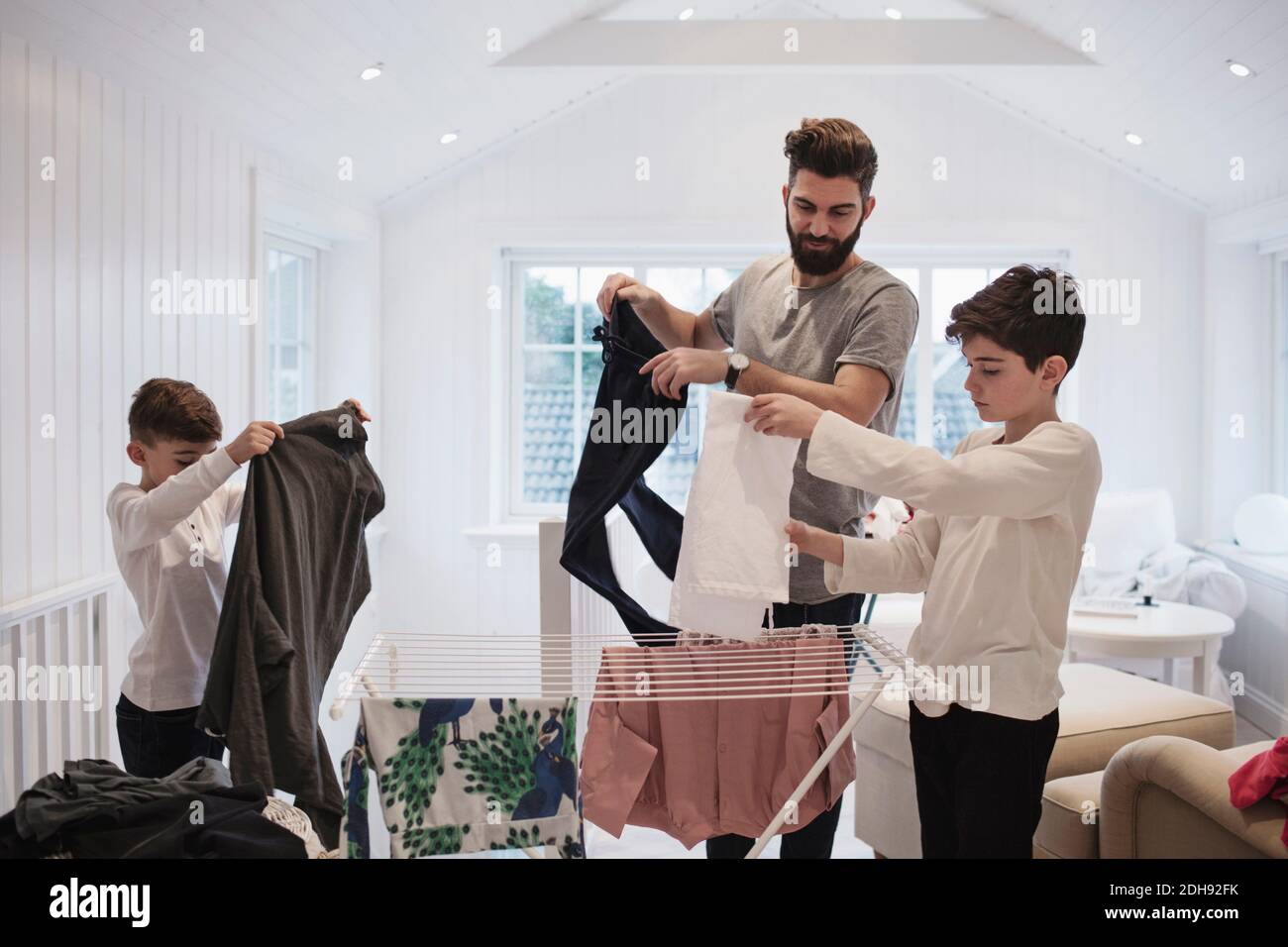 Vater und Jungen trocknen Kleidung zu Hause Stockfoto