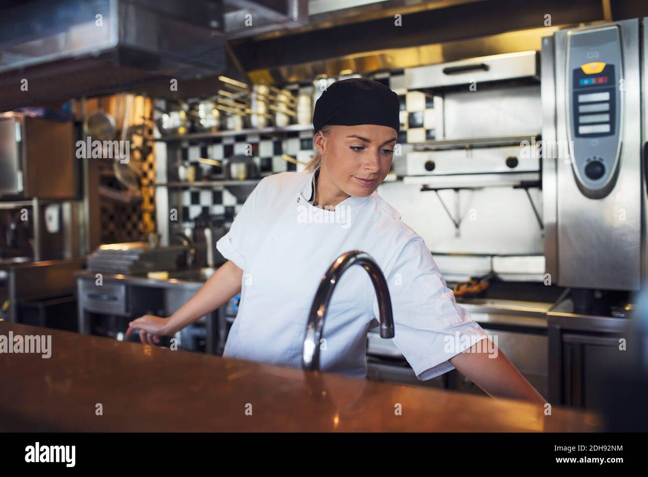 Junge Köchin, die in der Küche des Restaurants arbeitet Stockfoto