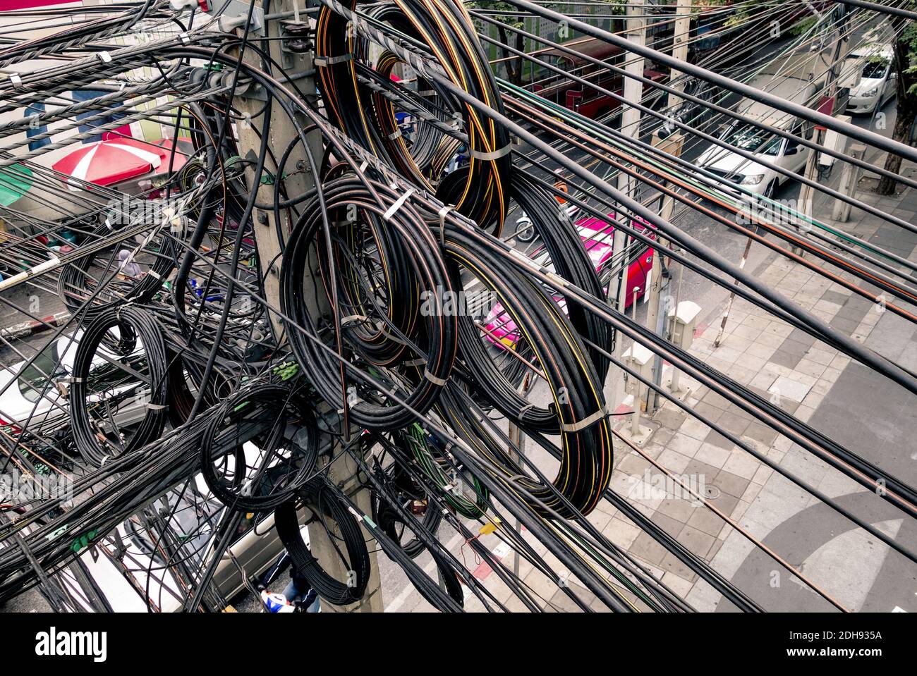 Chaotische elektrische Kabel in Bangkok - Beispiel für nicht abgedeckte optische Glasfasertechnologie im Freien in südostasiatischen Städten Stockfoto