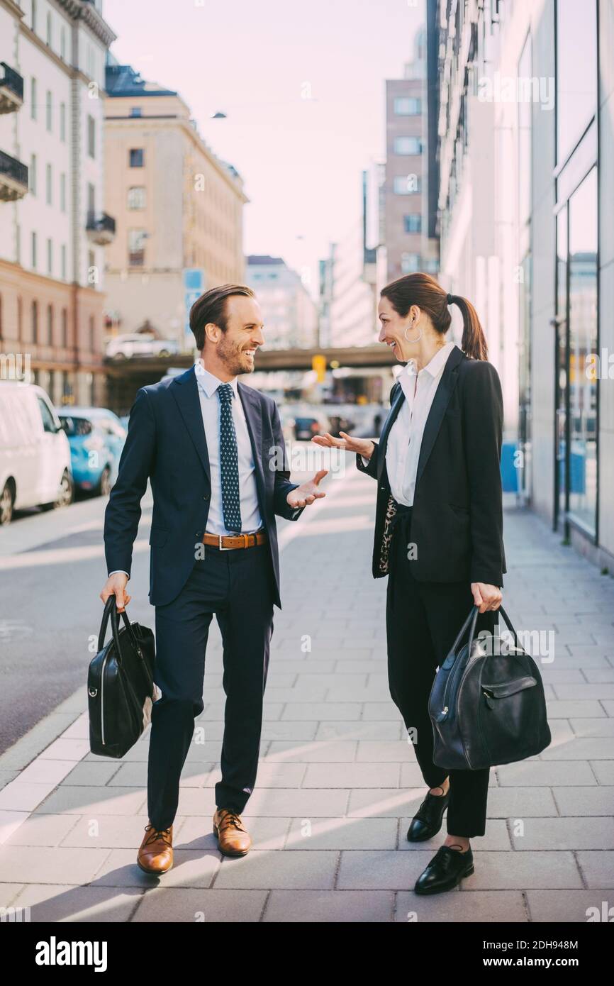 Glückliche Geschäftsleute stehen und reden auf dem Bürgersteig Stockfoto