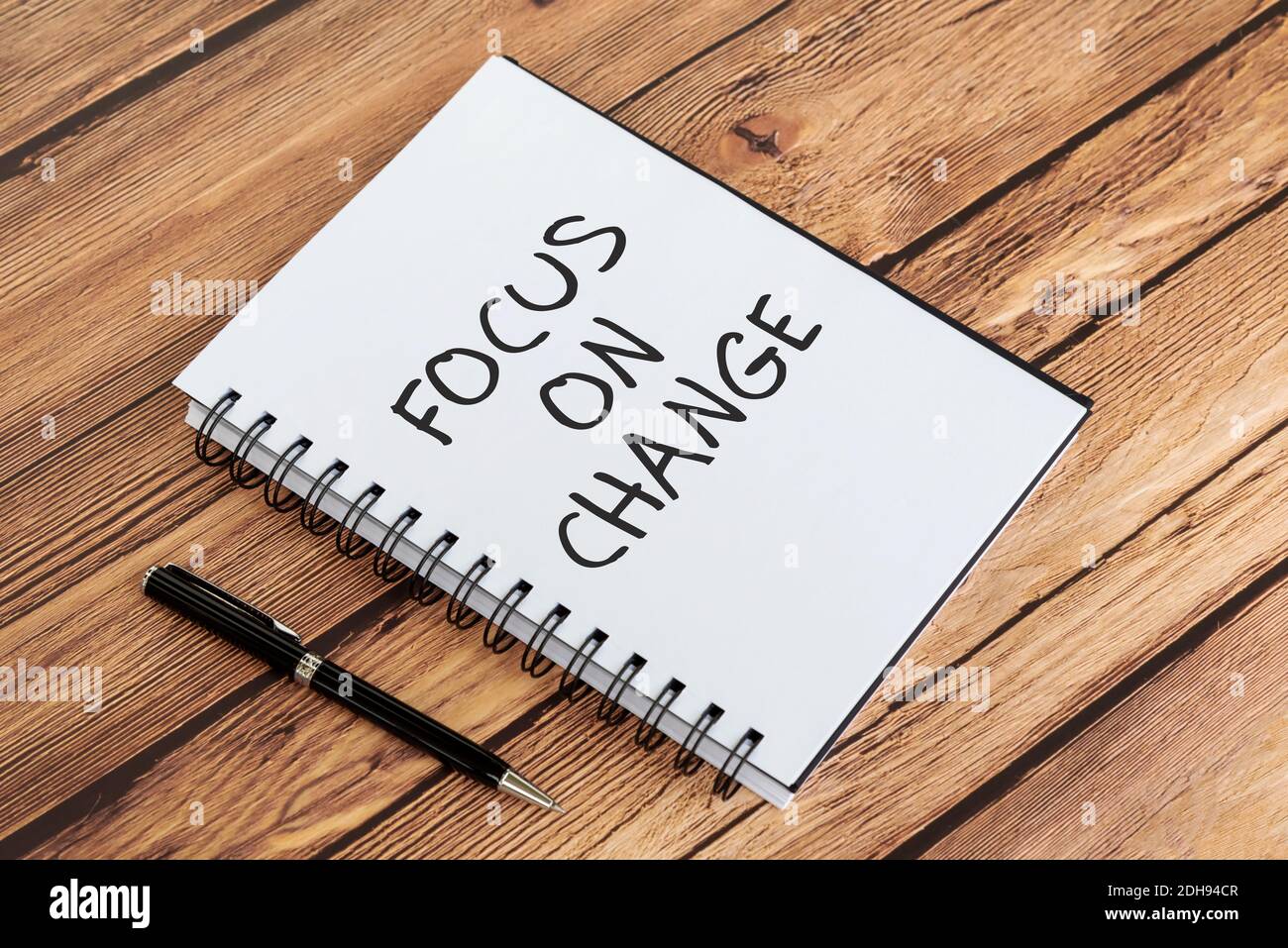 Inspirierende Zitate auf Notizblock - Fokus auf Veränderung. Holzhintergrund. Stockfoto