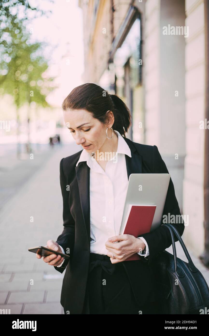 Geschäftsfrau mit Smartphone in Stadt Stockfoto