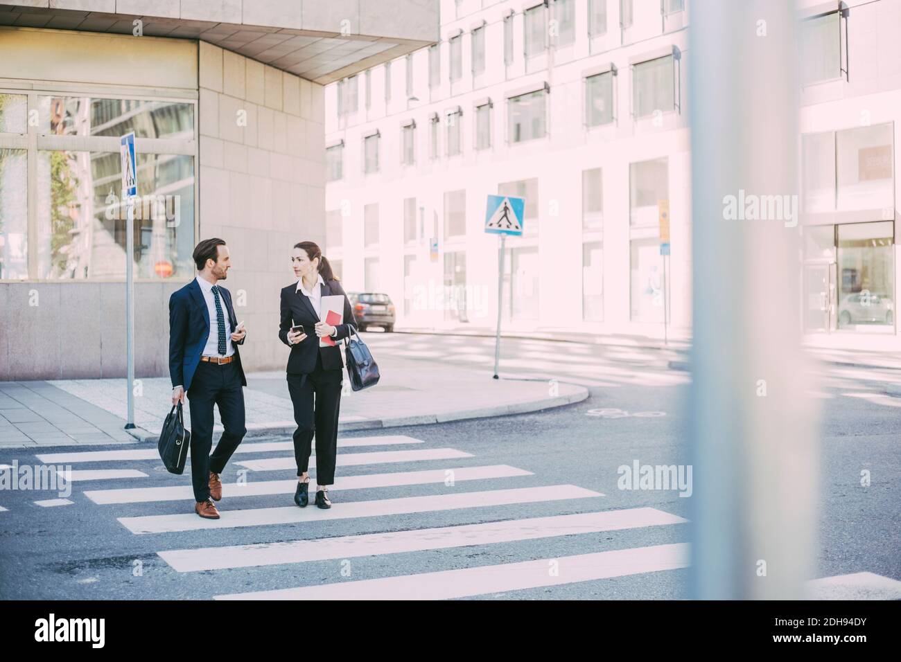 Volle Länge der Geschäftskollegen sprechen wile Kreuzung Straße in Stadt Stockfoto
