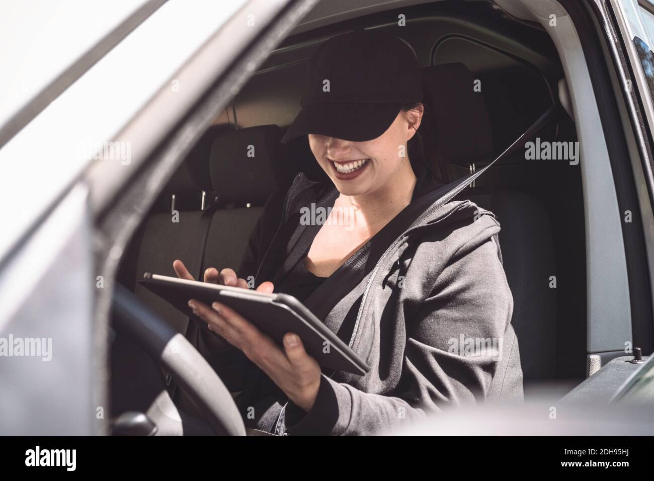 Lächelnde weibliche Fahrer mit digitalen Tablet in LKW Stockfoto