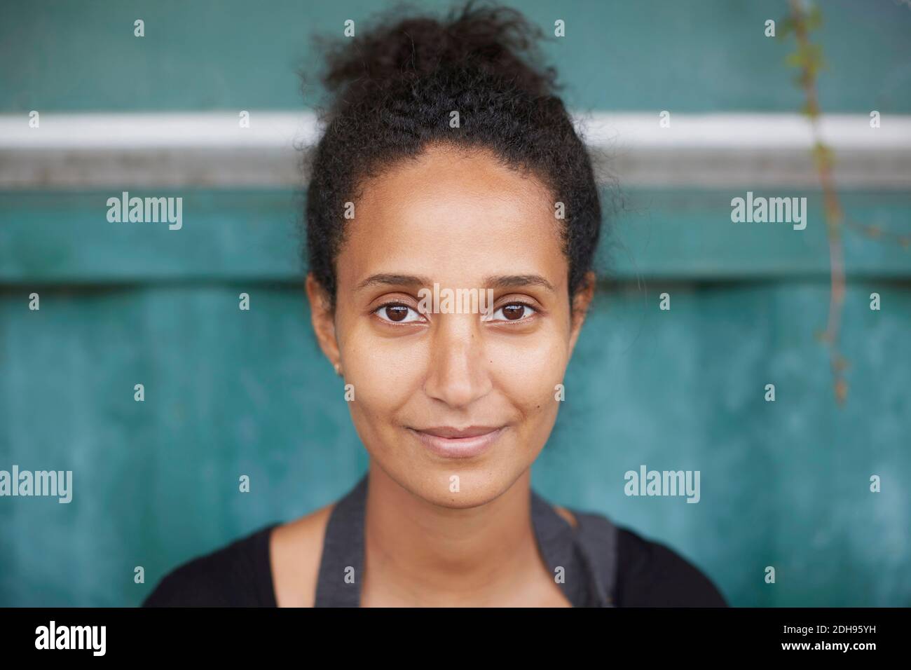 Porträt einer jungen Gärtnerin, die am Hof lächelt Stockfoto