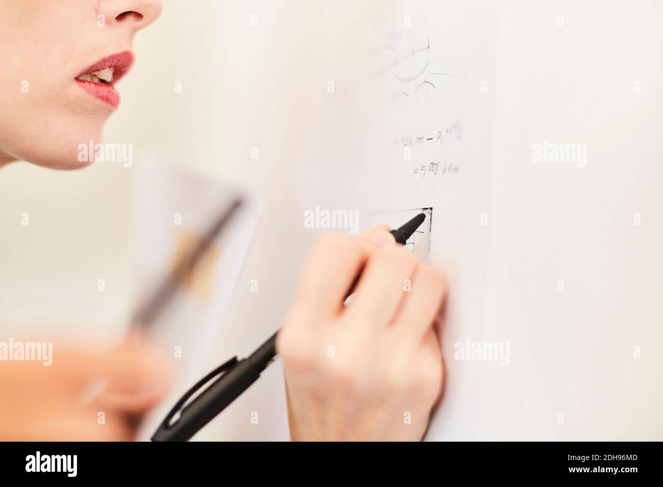 Zugeschnittenes Bild der Unternehmerin schreiben auf Whiteboard im Büro Stockfoto