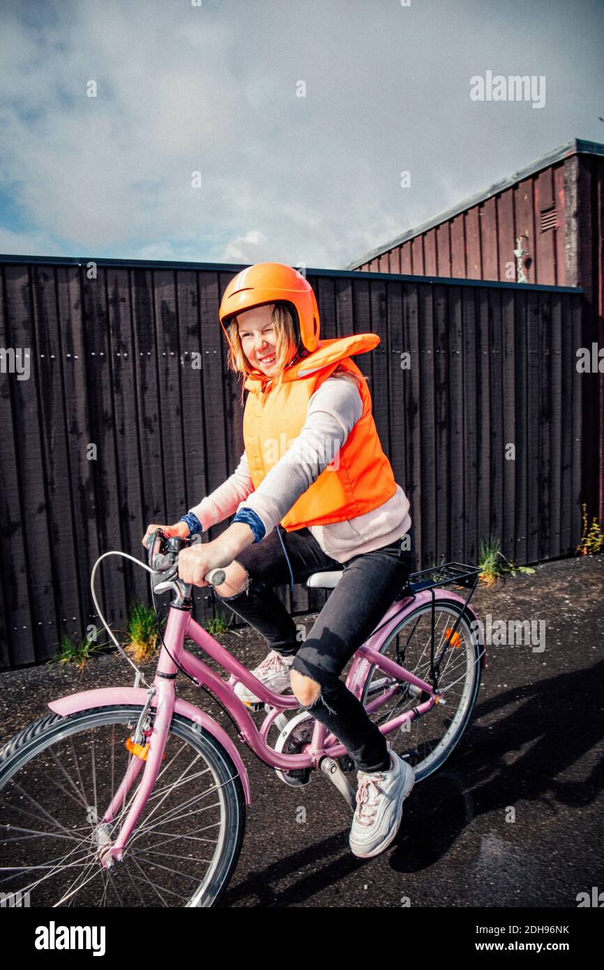 Lächelndes Mädchen Fahrrad fahren auf der Straße Stockfoto