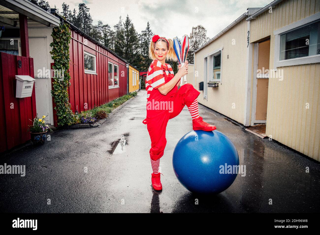 Porträt einer lächelnden Frau, die beim Fitnessball auf der Straße steht Stockfoto