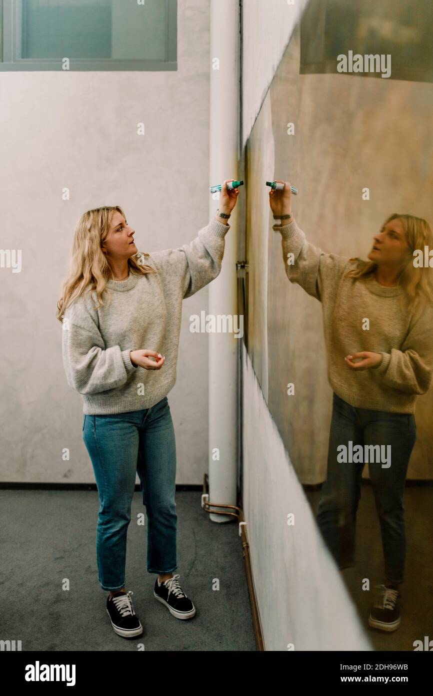 Geschäftsfrau Schreiben auf Acrylglas im Büro Stockfoto