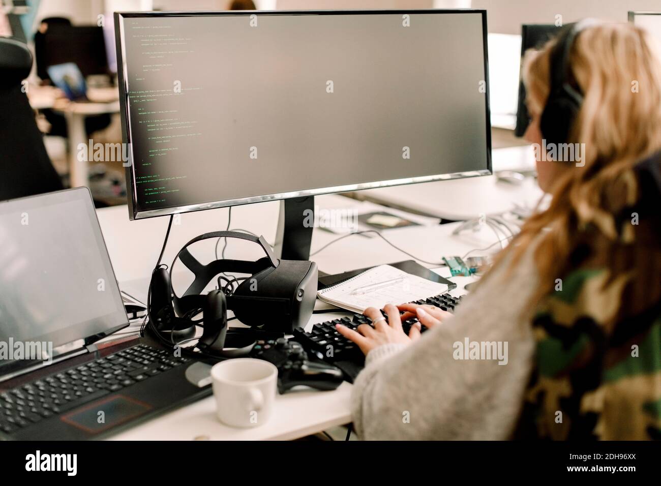 Rückansicht der Geschäftsfrau, die im Büro am Computer arbeitet Stockfoto