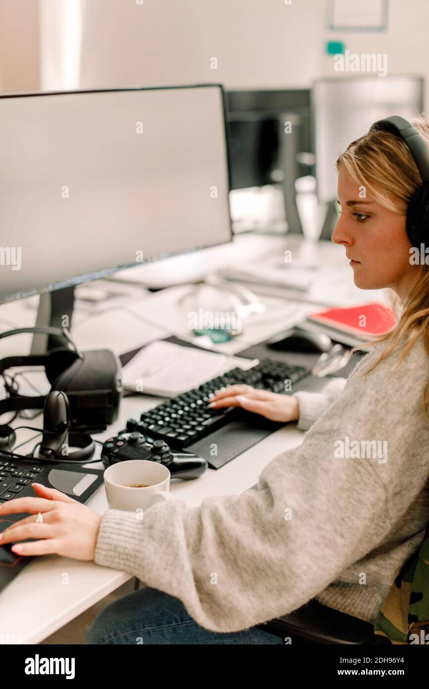 Seitenansicht einer Geschäftsfrau, die im Büro am Computer arbeitet Stockfoto