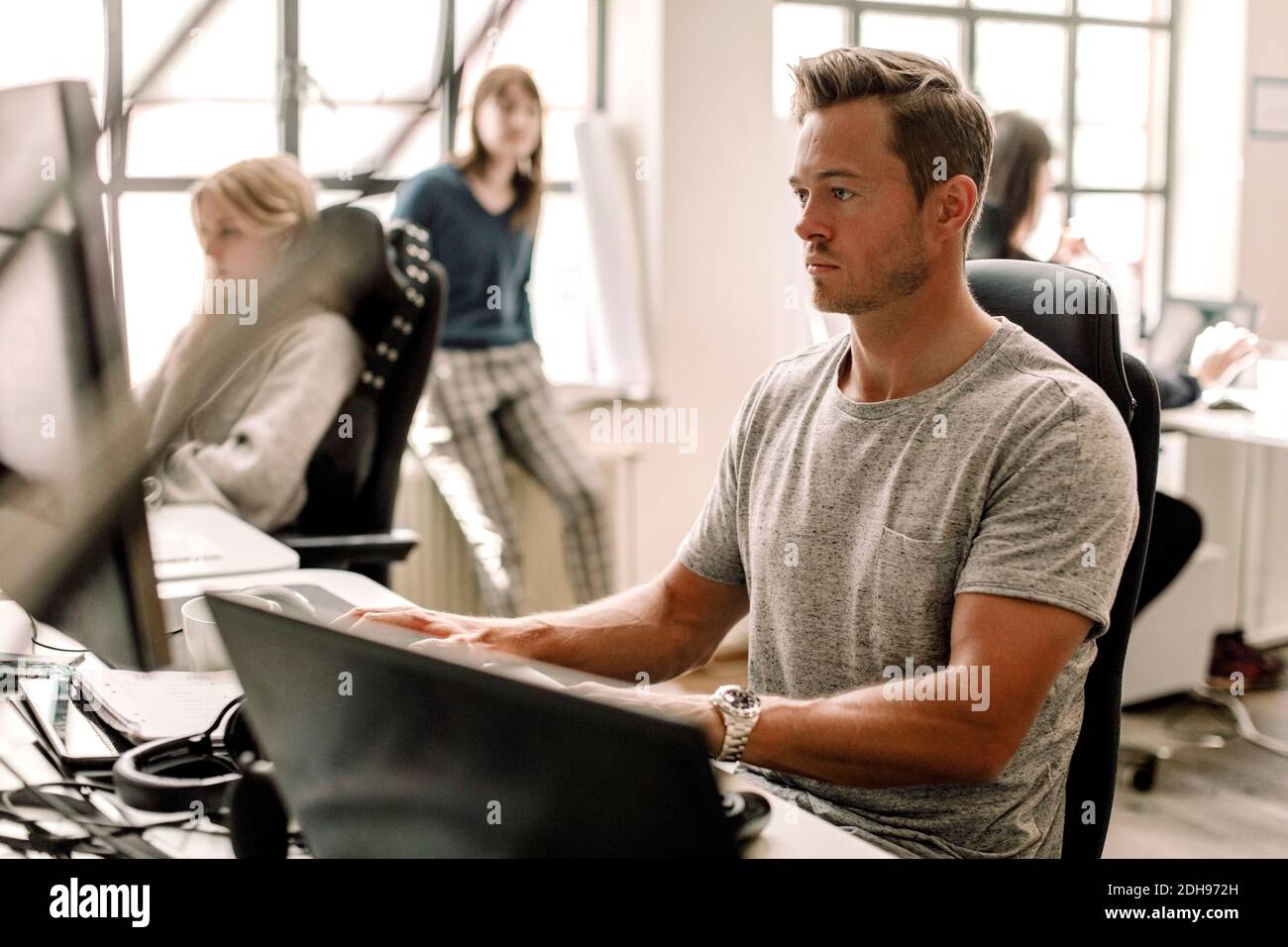 Männlicher Unternehmer, der am Arbeitsplatz am Computer arbeitet Stockfoto