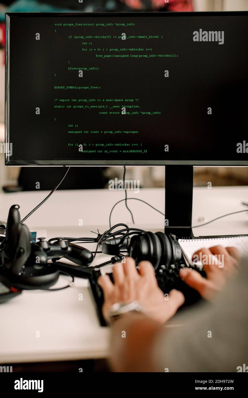 Verkürzte Hände des Unternehmers, der an der Computerprogrammierung am Arbeitsplatz arbeitet Stockfoto