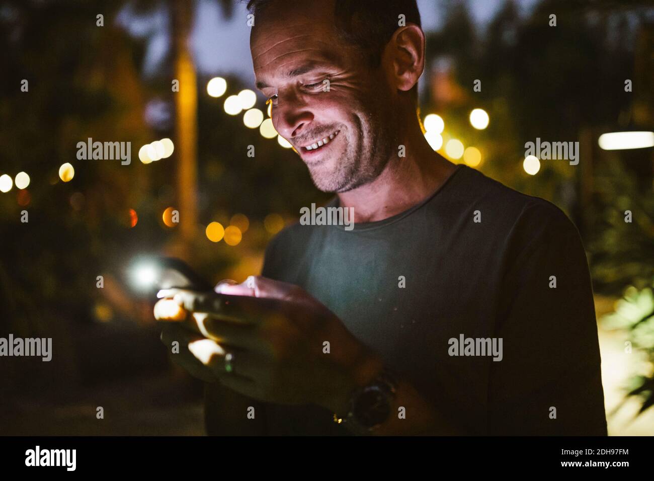 Lächelnder Mann schreibt während des Sonnenuntergangs Stockfoto