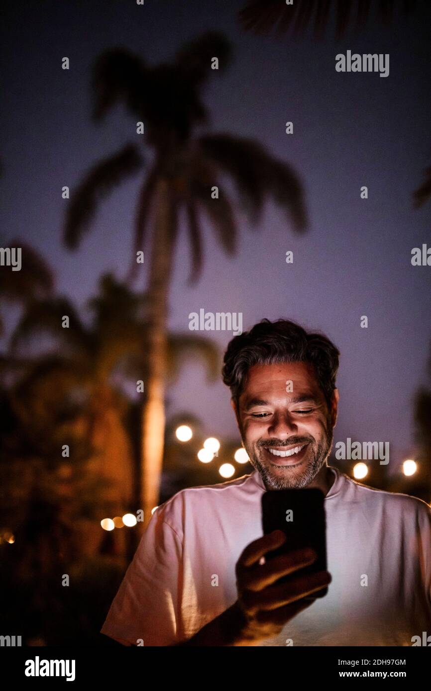 Low-Winkel-Ansicht von glücklichen Mann mit Telefon gegen klar Himmel bei Sonnenuntergang Stockfoto
