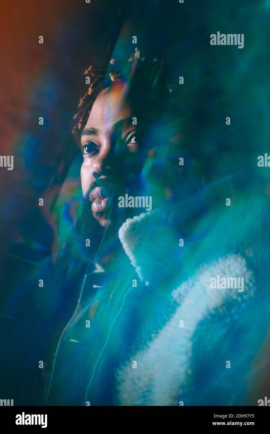 Junger Afro-Mann, der auf die beleuchtete Bar schaut Stockfoto