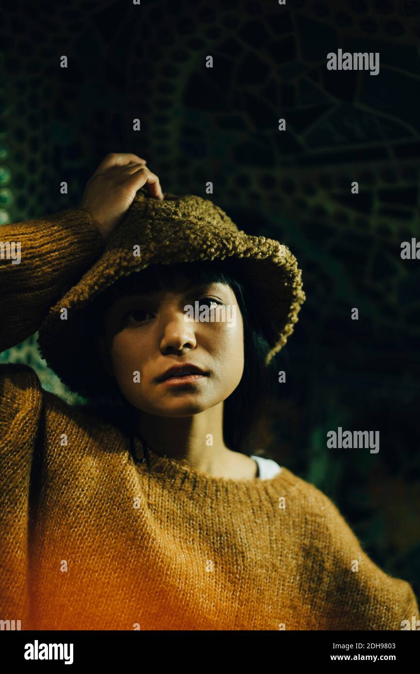 Porträt einer jungen Frau mit Kapuze im beleuchteten Restaurant Stockfoto