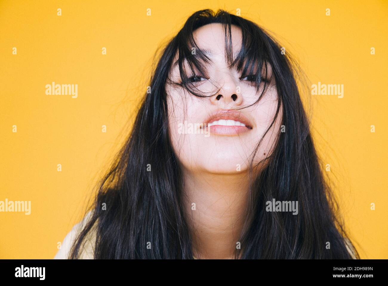 Nahaufnahme Porträt von verspielten Mädchen vor gelbem Hintergrund Stockfoto