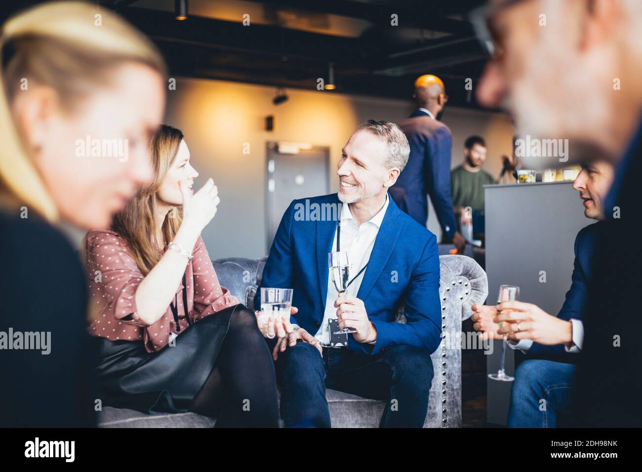 Lächelnde Geschäftsleute sprechen im Büro Stockfoto