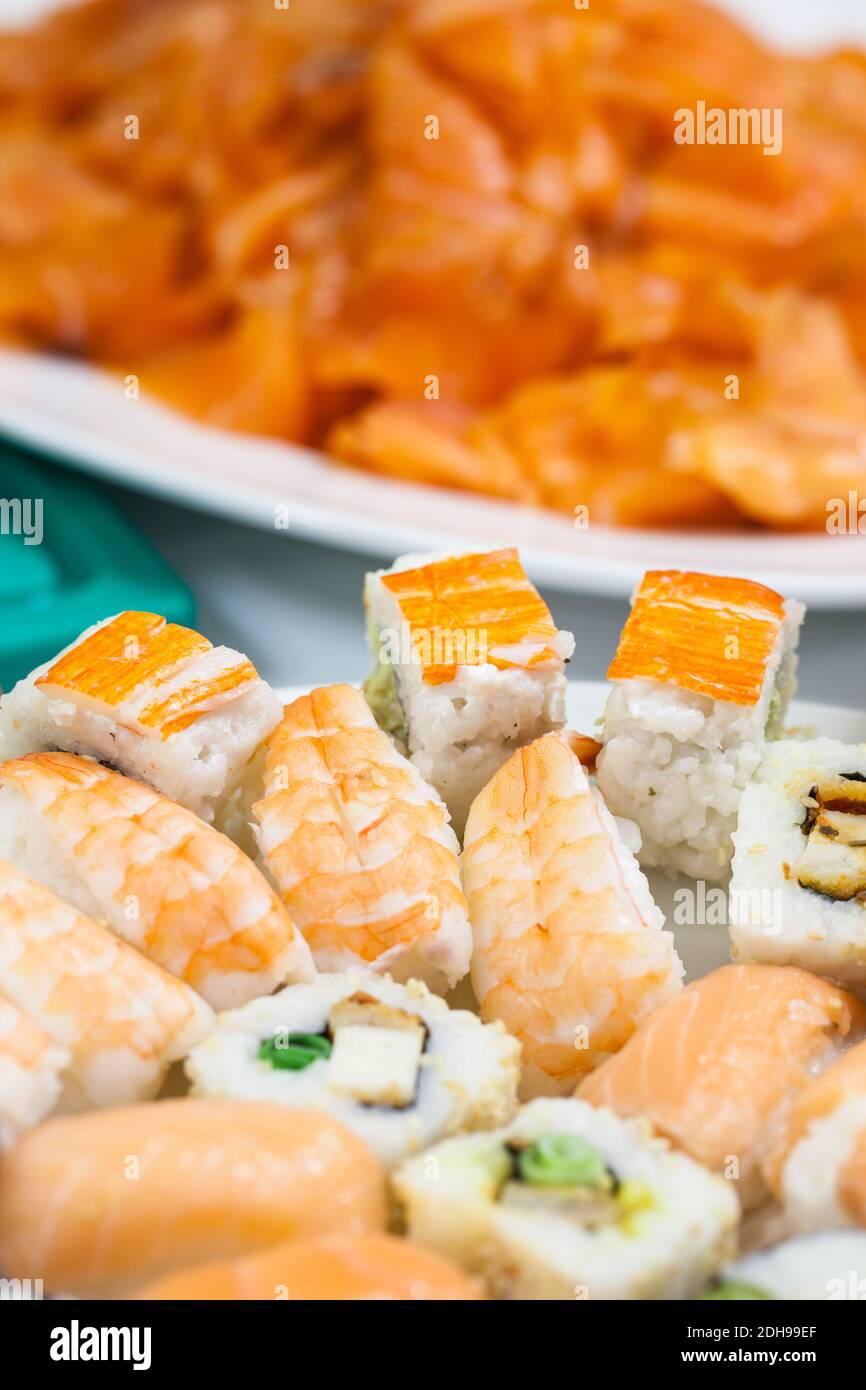 Fischbuffet: Auswahl an Sushi vor einem Teller mit Lachs Stockfoto