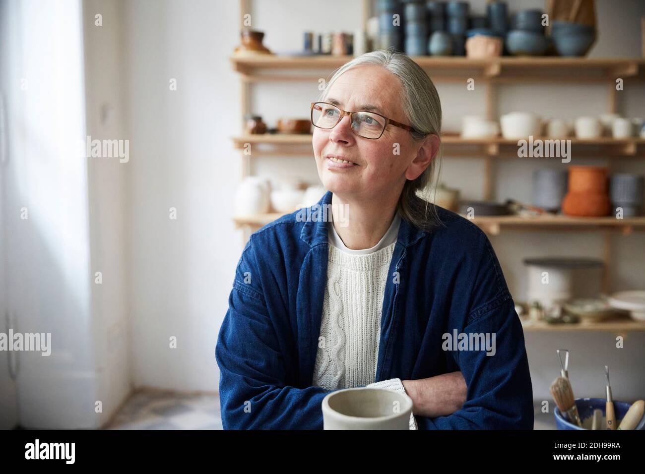 Nachdenklich reife Frau sitzt in Keramik-Klasse Stockfoto