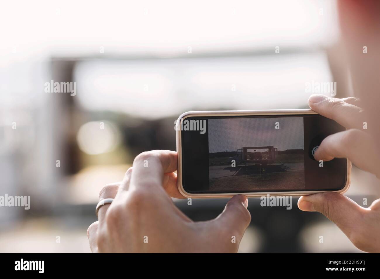 Zugeschnittenes Bild von Geschäftsreisenden, die einen tragbaren Bürowagen fotografieren Smartphone Stockfoto