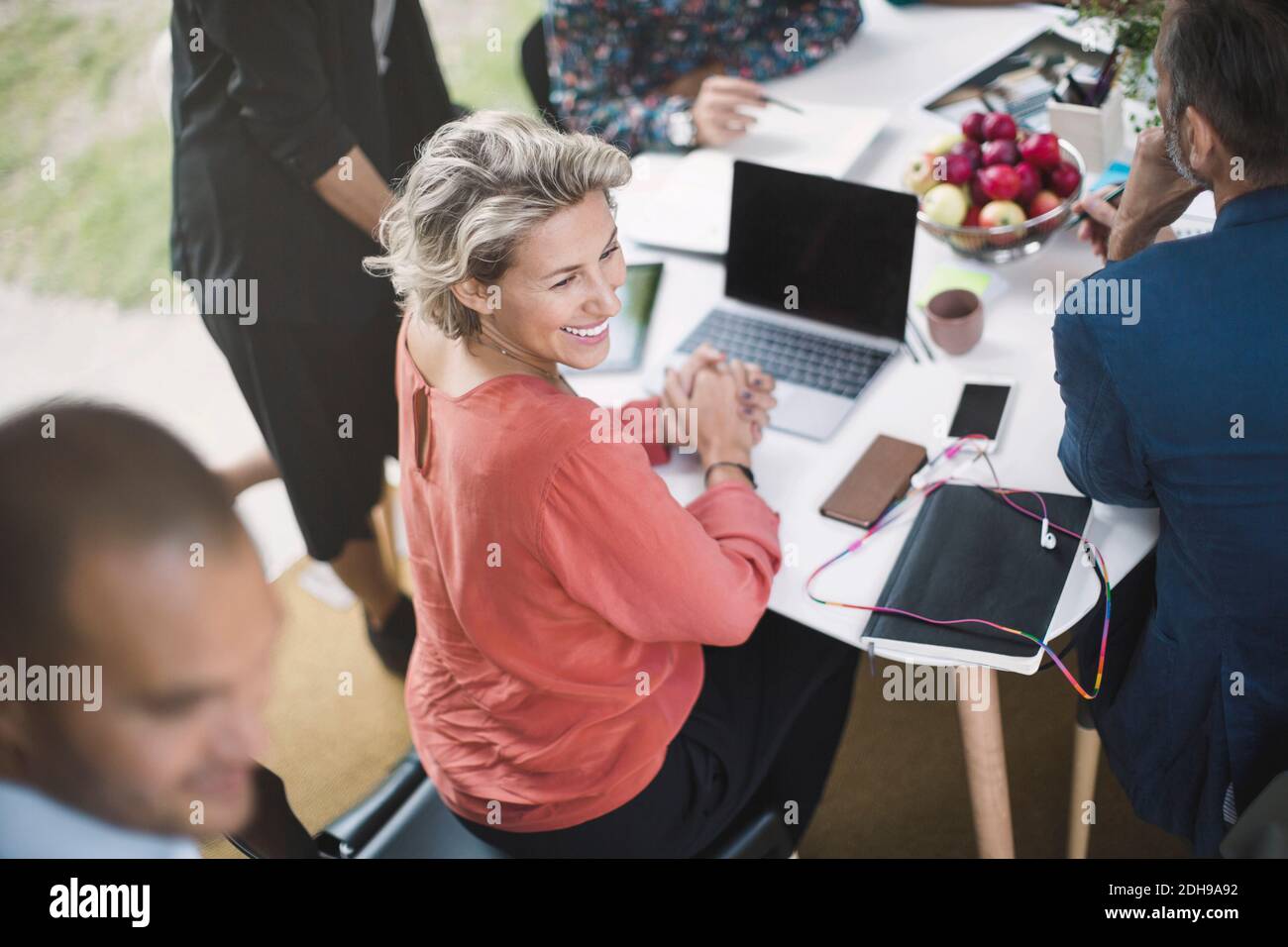 Glückliche Geschäftsfrau sitzt am Schreibtisch mit Kollegen in tragbaren Büro LKW Stockfoto