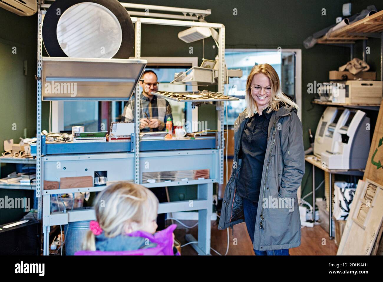 Glückliche Besitzerin mit Familie in der Brillen-Werkstatt Stockfoto