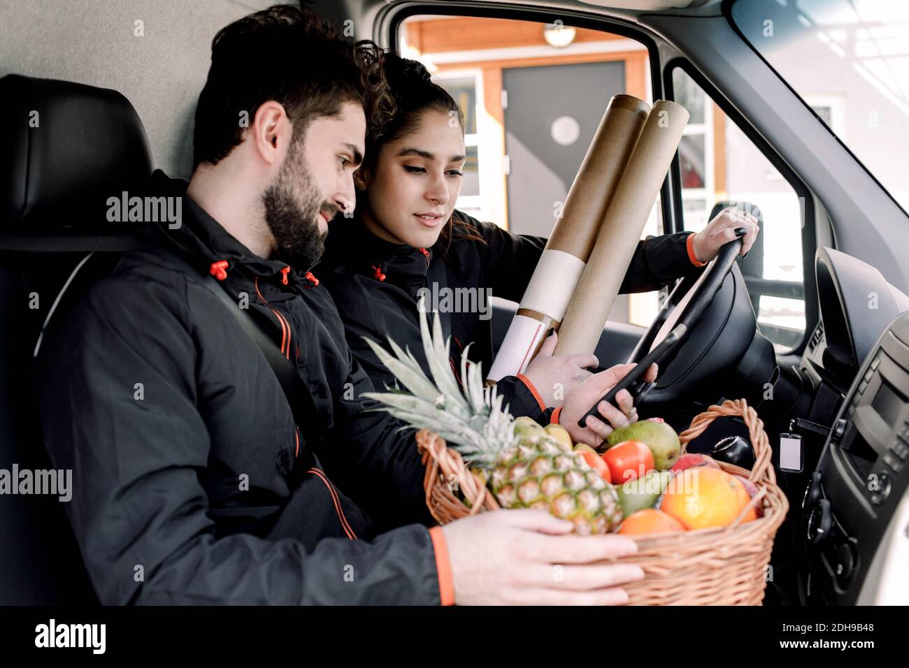 Junge Lieferung Mann und Frau mit Früchten und Pakete in LKW Stockfoto