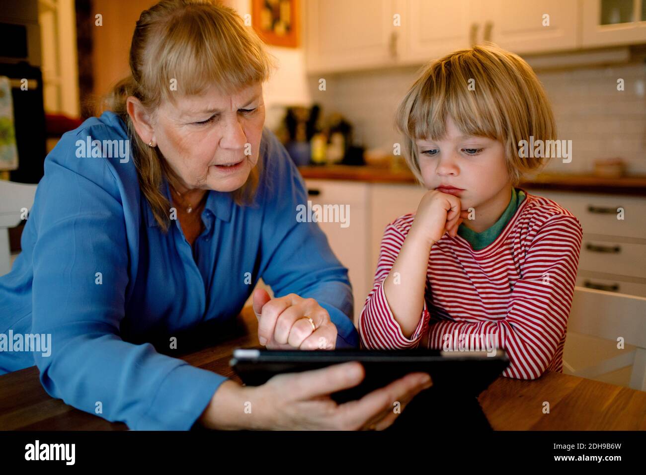 Junge Blick auf Großmutter mit digitalen Tablet Stockfoto