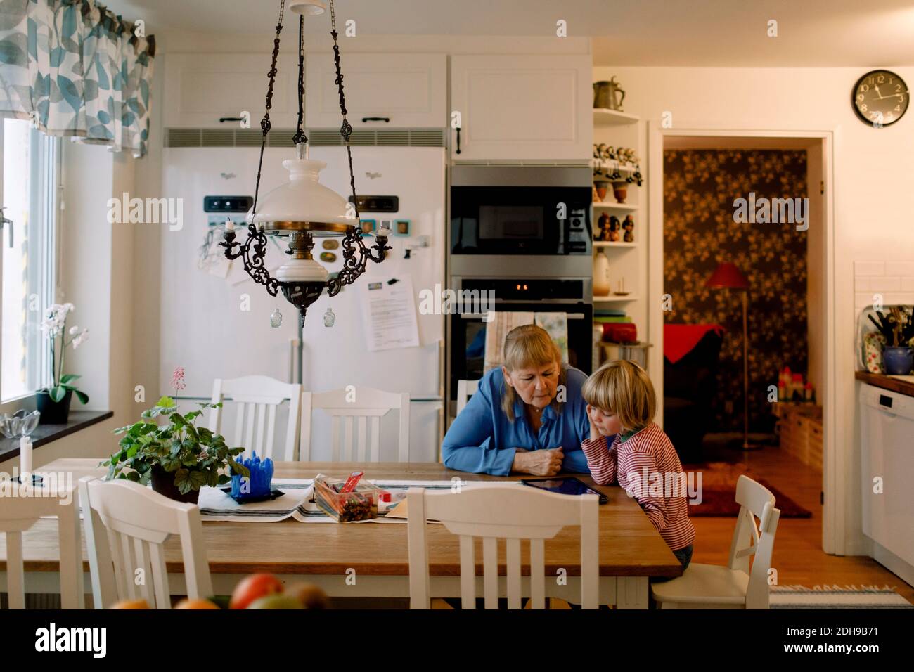Großmutter und Enkel mit digitalen Tablet beim Essen sitzen Tabelle Stockfoto